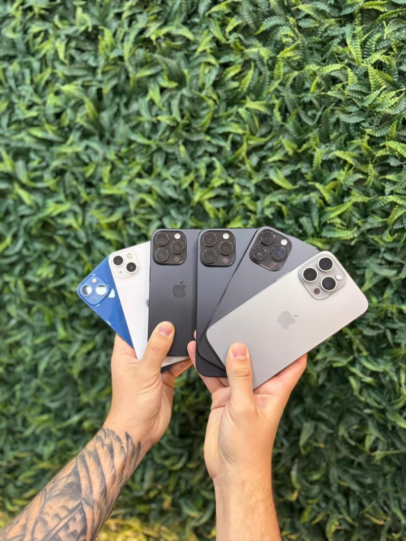 Seis iPhone de gerações e cores diferentes nas mãos