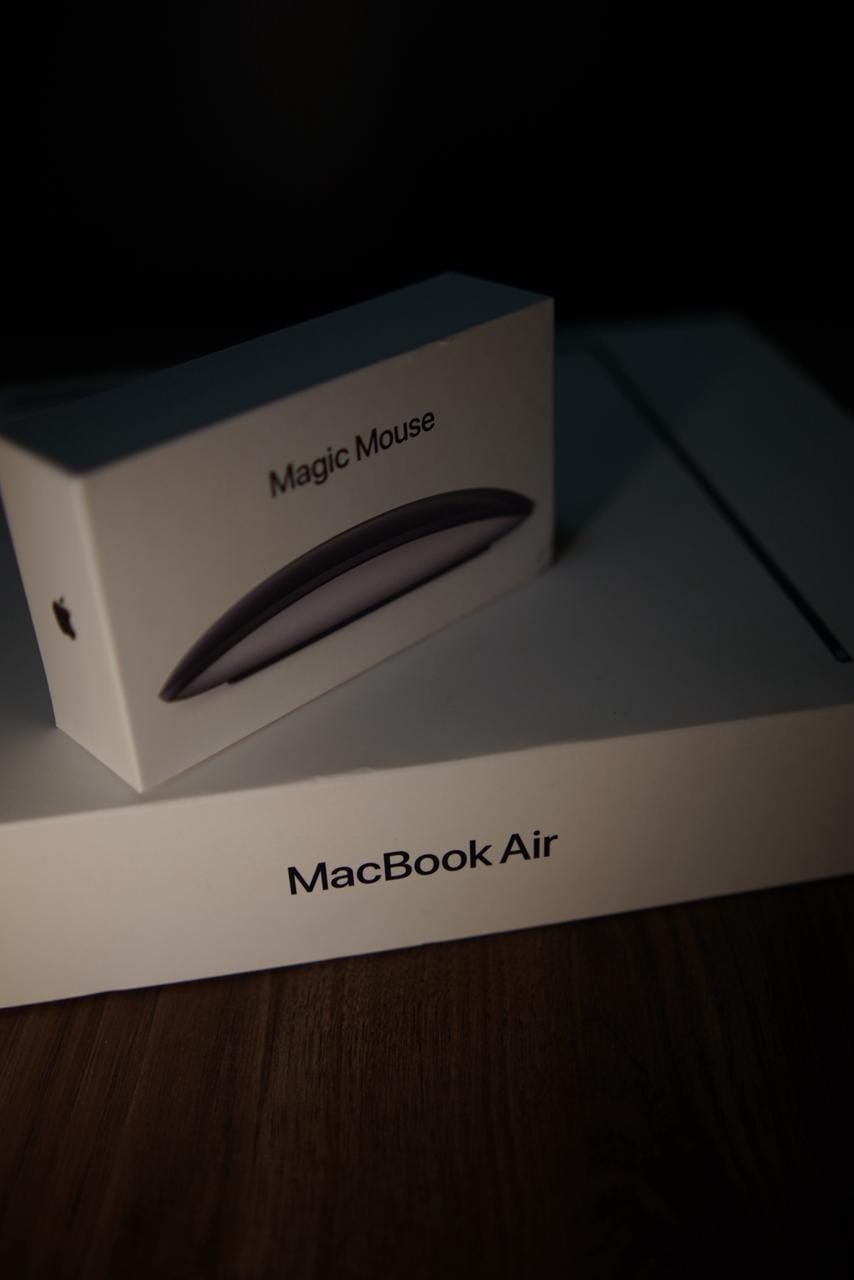 Caixa lacrada de MacBook Air ao lado de um Magic Mouse original